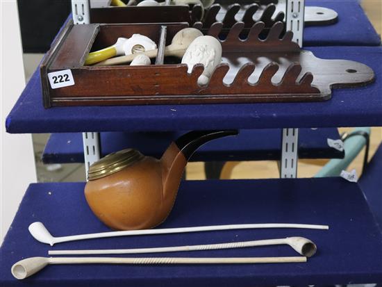 A pipe rack with clay pipes and novelty tobacco jar shaped as a pipe